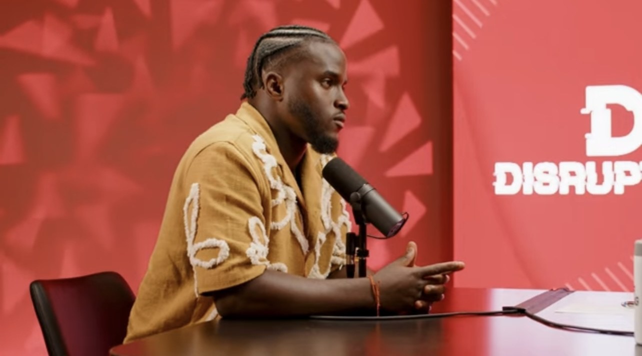 Olufemi speaking into a microphone during a podcast conversation